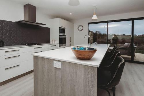 a kitchen with a wooden bowl on a counter at Bell Block Beauty - pristine 3BR home near beach in New Plymouth