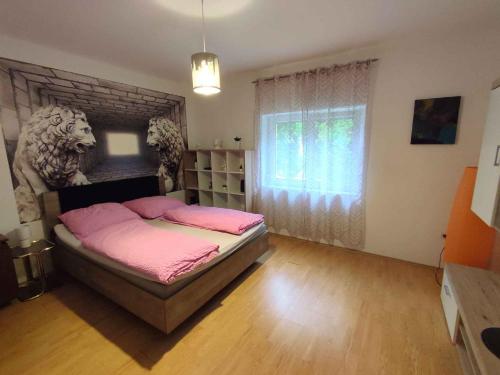 a bedroom with a bed with pink sheets and a window at Holiday home in Siofok - Balaton 45810 in Siófok