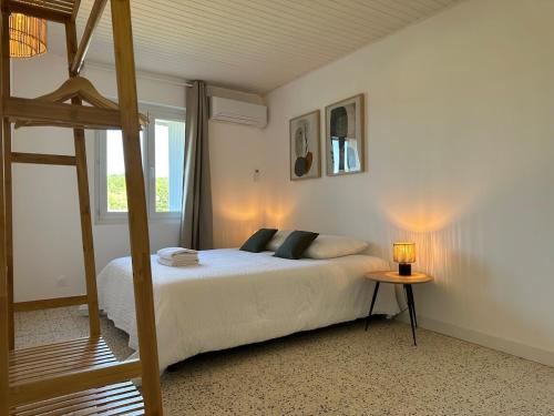 a bedroom with a bed with a ladder and a table at Villa Jeanne in Ners