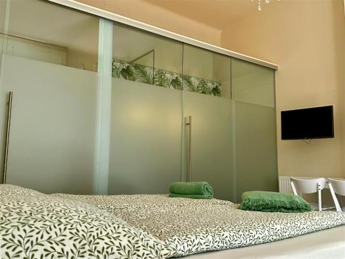 a bedroom with a large bed and a flat screen tv at SMARAGD - Doppelzimmer mit Küche direkt im Zentrum, Balkon in Bad Ischl
