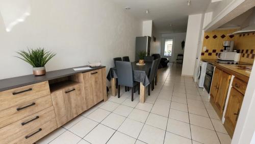 une cuisine et une salle à manger avec une table et des chaises dans l'établissement Maison de village avec patio, à Bonnac