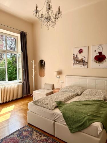 a bedroom with a bed and a chandelier at SMARAGD - Doppelzimmer mit Küche direkt im Zentrum, Balkon in Bad Ischl