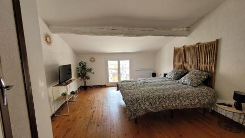 une chambre avec un lit et une télévision dans l'établissement Maison de village avec patio, à Bonnac