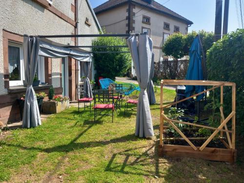 a garden with umbrellas and chairs in a yard at Le Camus in Belonchamp