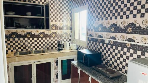 una cucina con piastrelle bianche e nere sul muro di LeLodge Djibouti a Gibuti