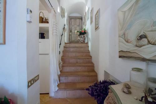 a stairway in a home with white walls and a staircase with a staircase at GuestHost - Porto Cervo Liscia di Vacca Apartment in Liscia di Vacca
