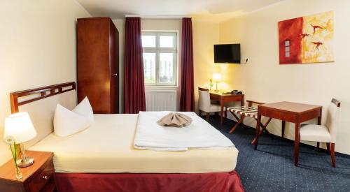 a hotel room with a bed and a desk at SchlafGut AppartementHotel in Leipzig