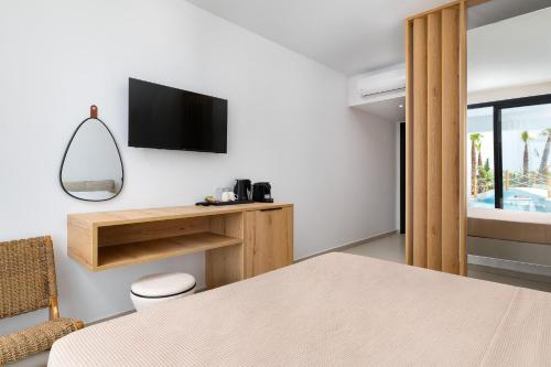 a room with a table and a tv on a wall at Martini Boutique Resort in Ialyssos