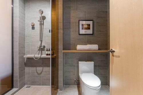 a bathroom with a toilet and a shower at Atour Hotel Suzhou University Town Yuexi Subway Station in Suzhou