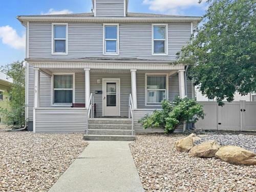 a gray house with a gravel driveway in front of it at Grand Lodge home in Grand Junction