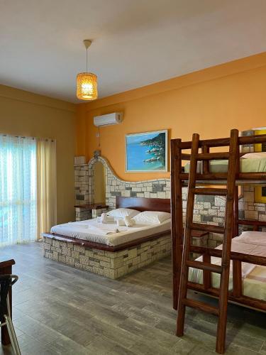 a bedroom with a bunk bed and a ladder at Hotel Adriatik Orikum in Orikum