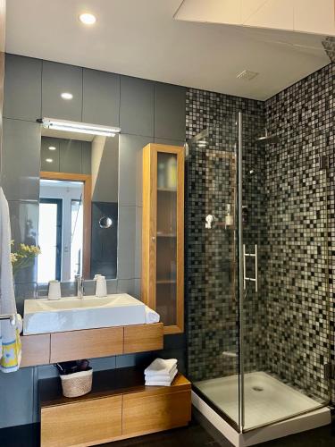 a bathroom with a tub and a sink and a shower at Crystal House in Angra do Heroísmo