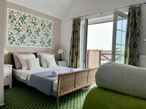 a bedroom with a bed and a large window at Siedlisko Kierzkowo in Kierzkowo