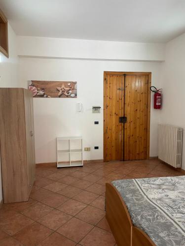 a bedroom with a bed and a wooden door at MarLo' Apartment in Tropea in Ciaramiti
