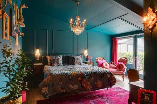 a blue bedroom with a bed and a chandelier at De Betovering in Zeewolde
