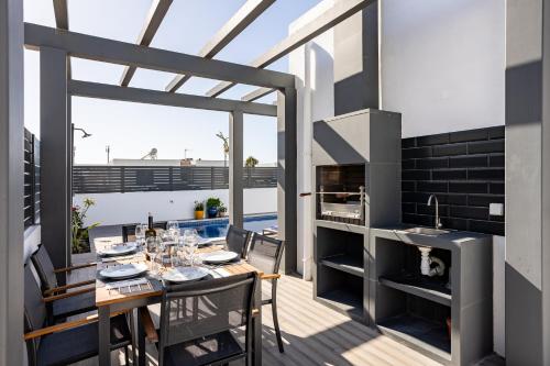 a dining room with a table and a fireplace at Villa Sal - Porto Covo in Porto Covo