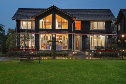 a house with a bench in front of a yard at Luxury 4BHK with Garden Pool and Entertainment Space in Palāhu