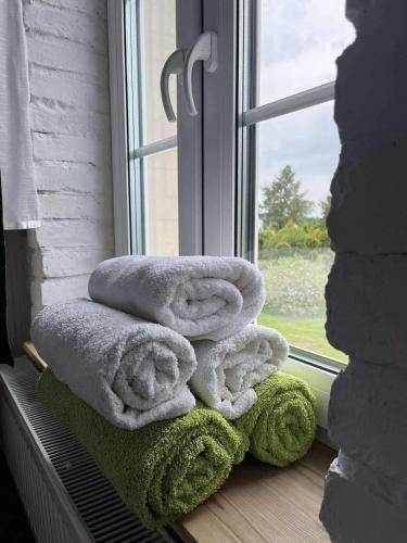 a pile of towels sitting on a window sill at Siedlisko Kierzkowo in Kierzkowo