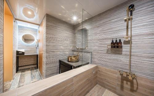 a bathroom with a shower with a sink and bottles of wine at Hotel Ravi in Seoul