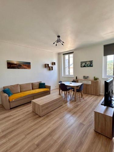 un salon avec un canapé et une table dans l'établissement L'embrun Fécampois, à Fécamp