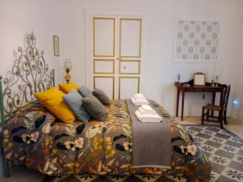 a bedroom with a large bed with yellow pillows at Villa Maggio in Acate