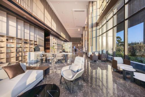 a lobby of a building with chairs and tables at Atour Hotel Nanchang Xiaolan Yingbin Middle Avenue in Nanchang