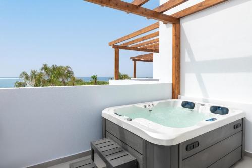 a bathroom with a bath tub on a balcony at Martini Boutique Resort in Ialyssos
