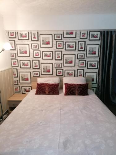 - une chambre avec un lit et un mur avec des photos dans l'établissement Guest house dans jardin exotique, quartier calme, jacuzzi, parking gratuit, à Morlaix
