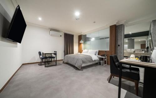 a hotel room with a bed and a table and chairs at Hotel AND in Suwon