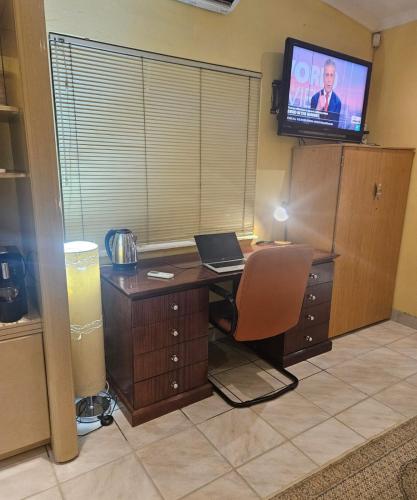 an office with a desk with a laptop and a television at RPG Corporate Unit in Johannesburg