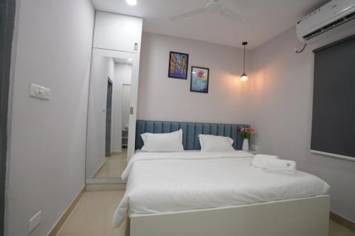 a bedroom with a large bed with white sheets at New Prestige Hotel in Hyderabad