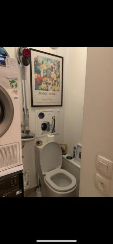 une salle de bain avec toilettes et un tableau au mur dans l'établissement Puteaux-La Défense, appartement haut standing, à Puteaux