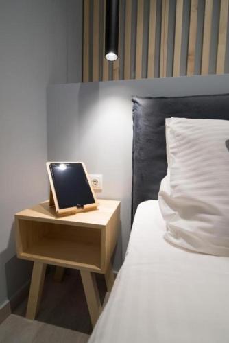 a laptop computer sitting on a night stand next to a bed at Preveza Central Stay in Preveza