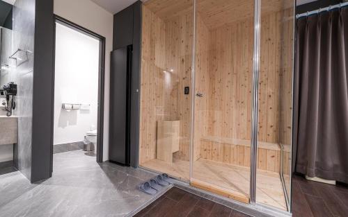a bathroom with a shower with a wooden wall at Hotel AND in Suwon