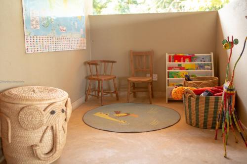 a room with a table and chairs and a rug at Zua Safari Lodge in Chikwawa