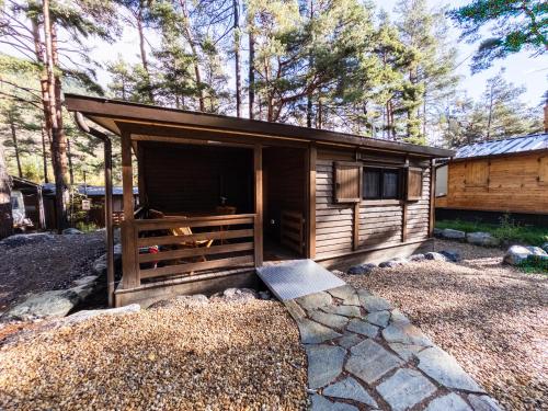 a wooden cabin with a large window in a yard at Campeggio Beaulard in Beaulard