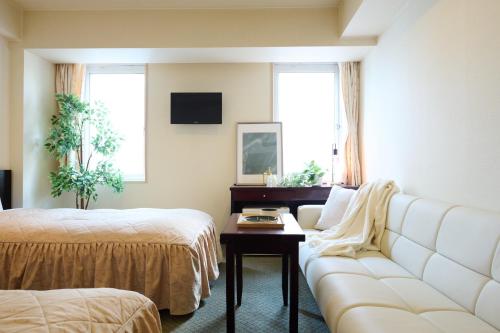 a living room with a couch and a bed and a table at Hotel Sho Sapporo - Vacation STAY 61184v in Sapporo