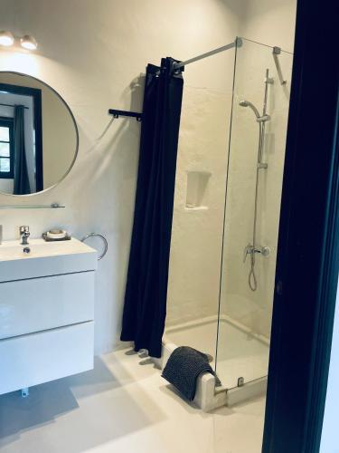 a bathroom with a shower with a glass shower curtain at Finca Malvasia Rural Estate & Vineyard in Tías