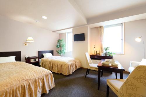 a hotel room with two beds and a table at Hotel Sho Sapporo - Vacation STAY 61187v in Sapporo