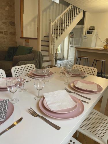 une table avec des assiettes et de l'argenterie au-dessus dans l'établissement Maison de famille, à Douarnenez