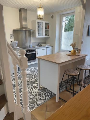 - une cuisine avec îlot central et comptoir dans l'établissement Maison de famille, à Douarnenez