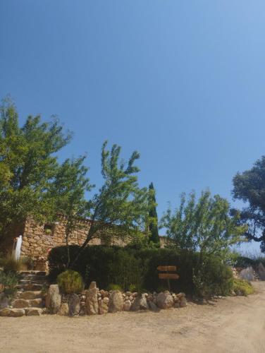 a stone building with a sign and some trees at holiday home su Niberalzu in Monti