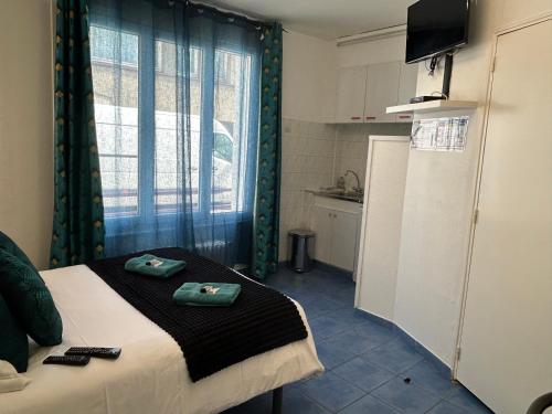 a small room with a bed and a kitchen at Hôtel et Appart 'hôtel Chez Gino ETAPLES-Le Touquet in Étaples