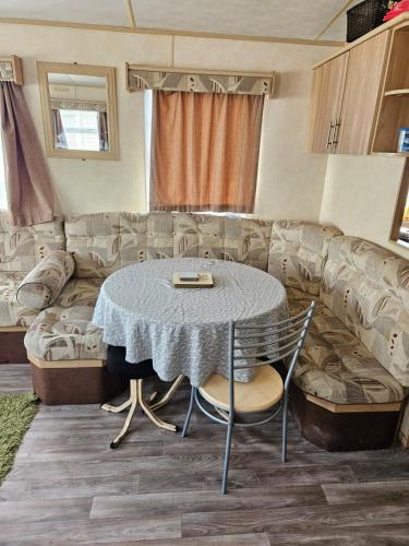 una sala de estar con una mesa y un sofá en PMH rental, en Saint Osyth
