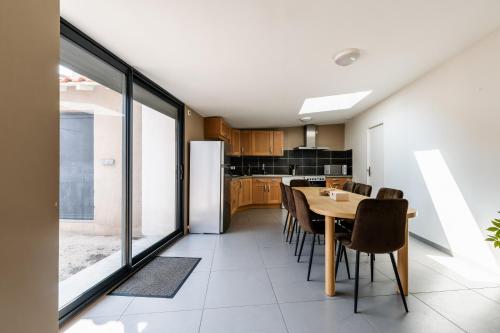 une cuisine et une salle à manger avec une table et des chaises dans l'établissement Le Vignoble, à Tain-lʼHermitage