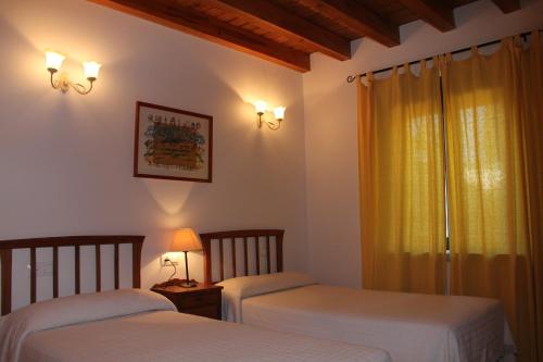 a bedroom with two beds and a window at Casa Rural El Alfar in Tajueco
