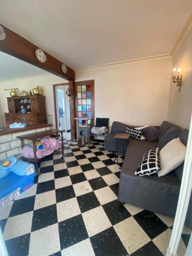 - un salon avec un canapé et un sol en damier dans l'établissement Grande Maison familiale 50m de la plage - Le nid d'Asnelles, à Asnelles