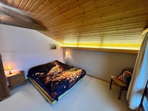 a bedroom with a bed and a wooden ceiling at Large vacation home with mountain views in Quarten