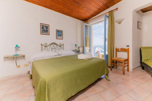 a bedroom with a bed and a large window at Hotel Sunset Green in Ischia