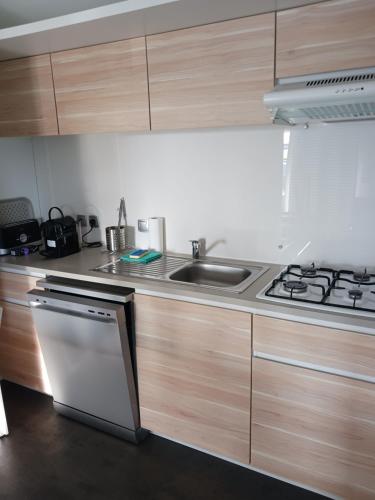 une cuisine avec un évier et une cuisinière dans l'établissement Sous le soleil d'Opale, à Le Portel
